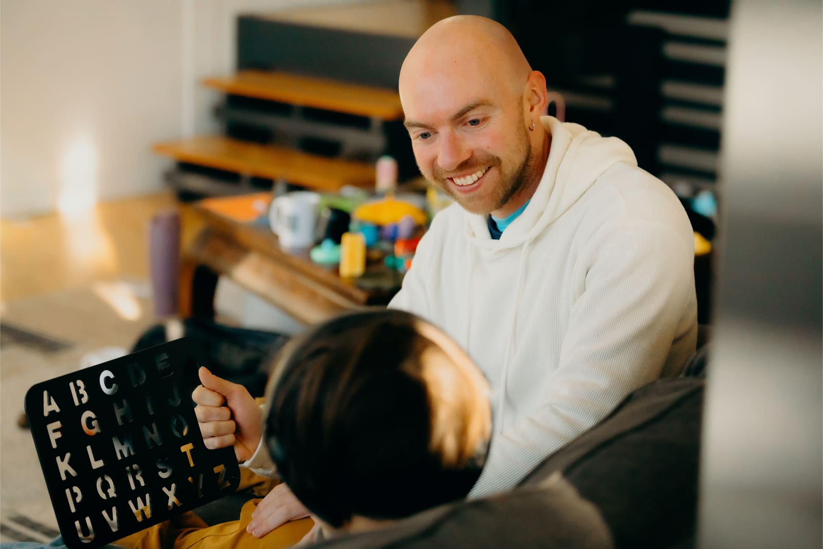 Adam trabajando con un niño en un tablero de letras